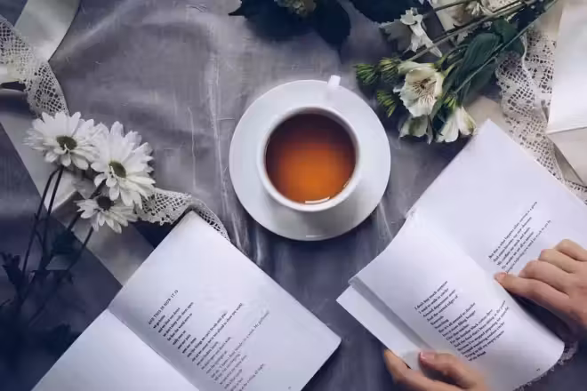 Une tasse de thé et des livres fleuris créant une ambiance sereine, parfaite pour étudier ou se livrer à une contemplation poétique.