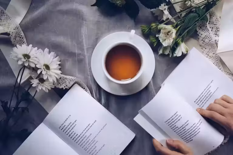 Une tasse de thé et des livres fleuris créant une ambiance sereine, parfaite pour étudier ou se livrer à une contemplation poétique.