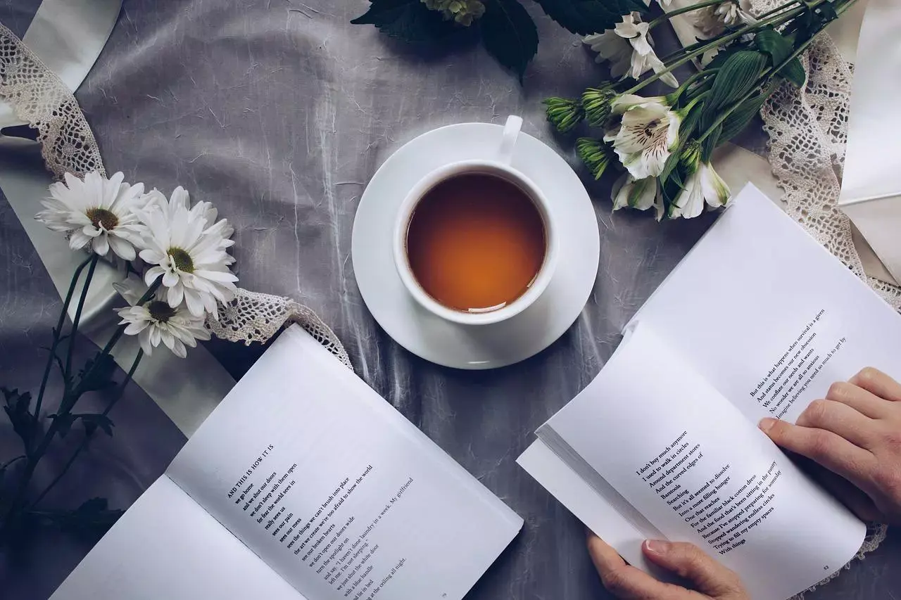Une tasse de thé et des livres fleuris créant une ambiance sereine, parfaite pour étudier ou se livrer à une contemplation poétique.